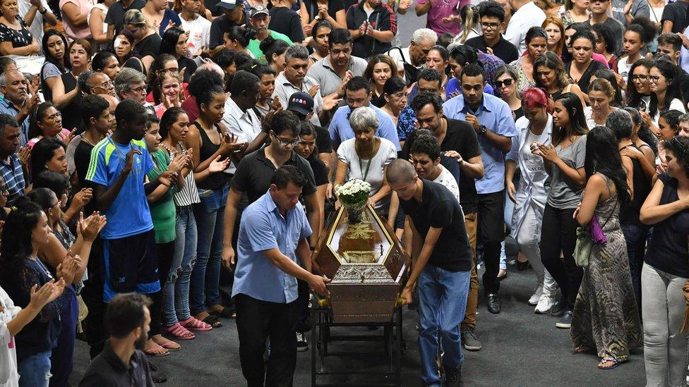 The coffin of one of the victims of the Raul Brasil public school shooting is wheeled by mourners