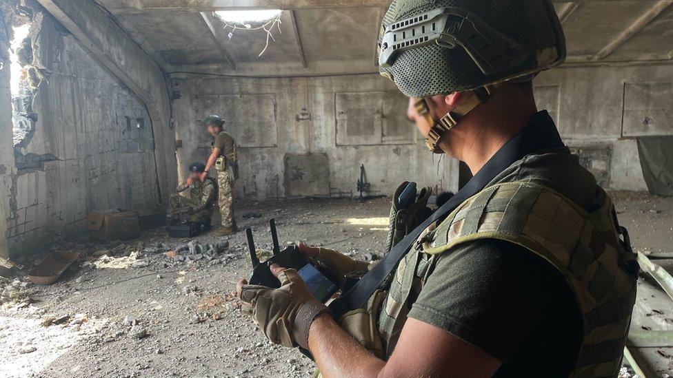 Pilot controlling and monitoring drone from inside a hangar