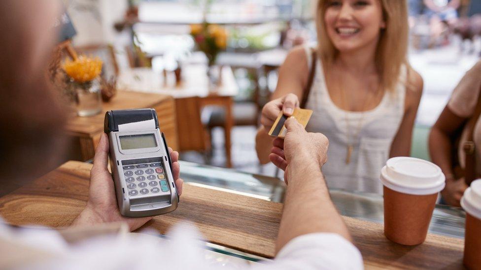 Woman paying in coffee shop