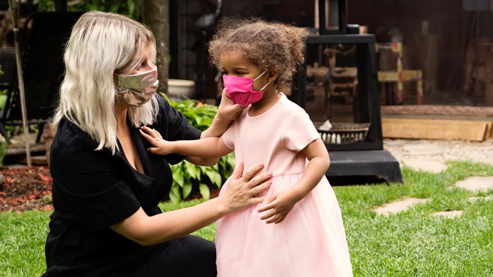 A woman and child in face coverings