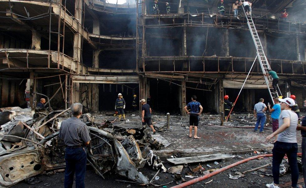 People gather at the site of a suicide car bomb in the Karrada shopping area, in Baghdad, Iraq July 3, 2016