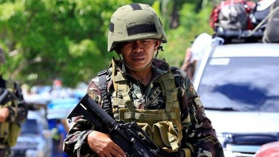 Government troops stand on guard during a checkpoint along a main highway in Pantar town, Lanao del Norte, after residents started to evacuate their hometown of Marawi city, southern Philippines May 24, 2017.