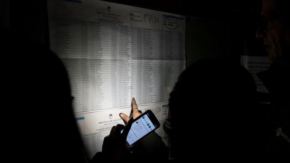 A voter looks at a electoral list during a blackout in Argentina