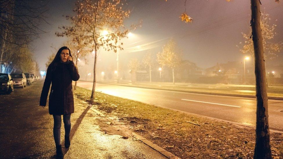 Woman on the phone, walking alone at night