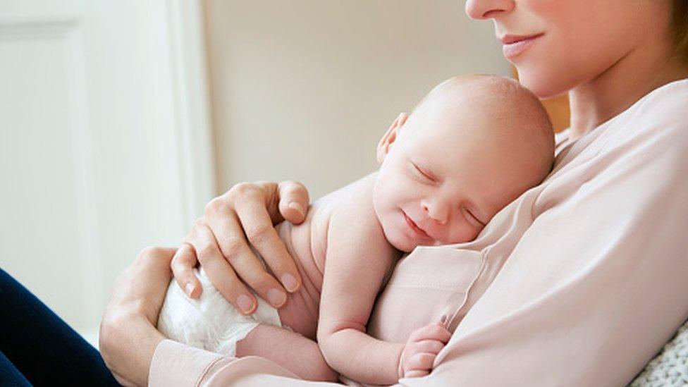 A woman holding a baby