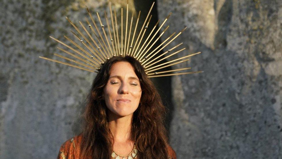 A woman soaks up the sun as she celebrates the summer solstice