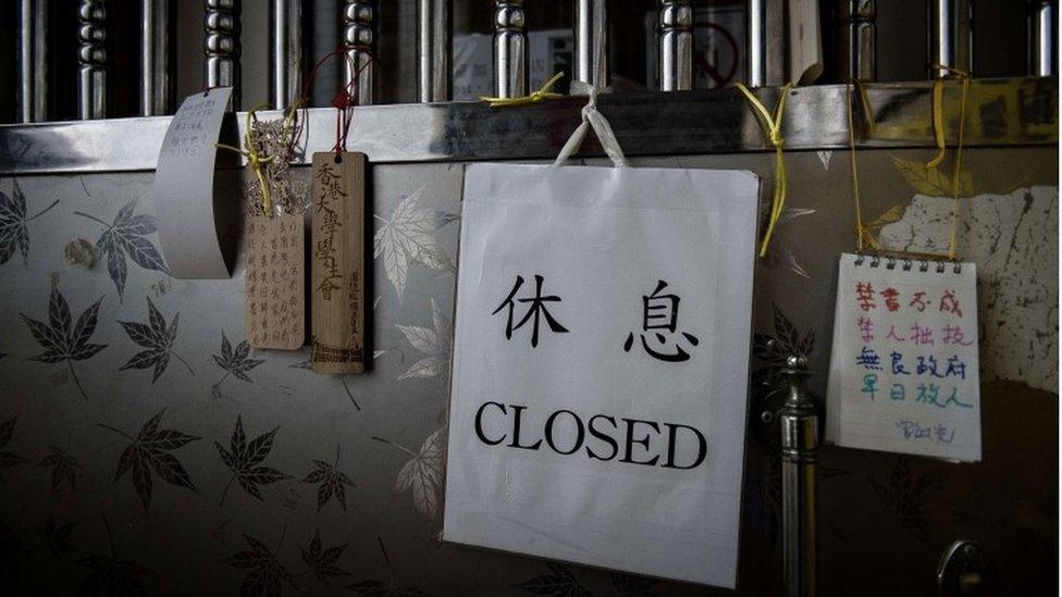 Messages of support (L and R) are seen hanging on the door of a closed bookshop selling books about China's politics in Hong Kong on January 4, 2016