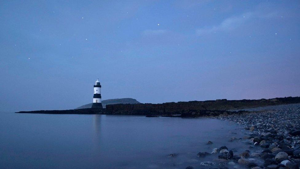 Penmon Lighthouse reflecting off the sea on Anglesey