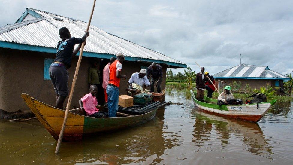 Rescue boats evacuate families after their houses were flooded in K'akola village in Nyando sub-county in Kisumu