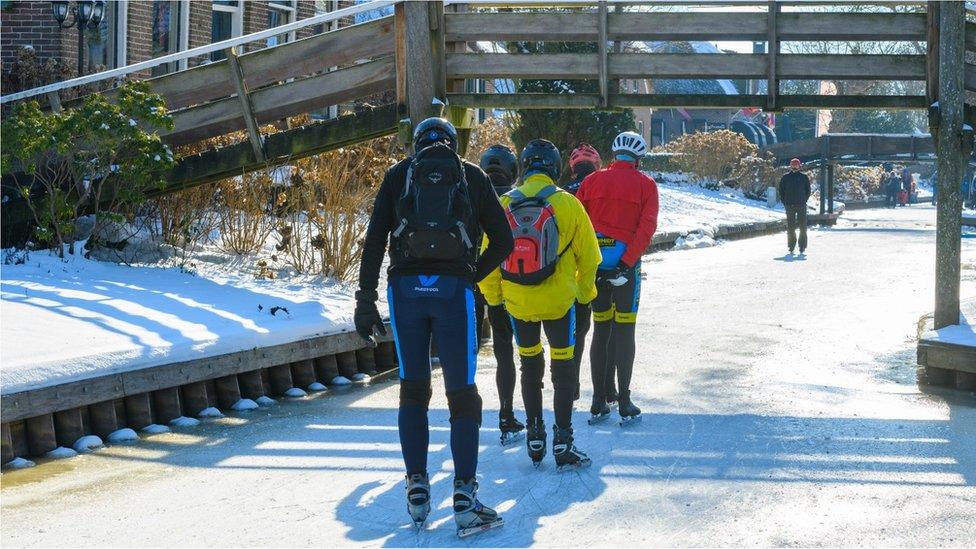 People ice skating on a frozen canal in the water village of Giethoorn in the Weerribben-Wieden nature reserve in Overijssel during a cold winter day in The Netherlands on February 12, 2021 in Giethoorn, Netherlands.