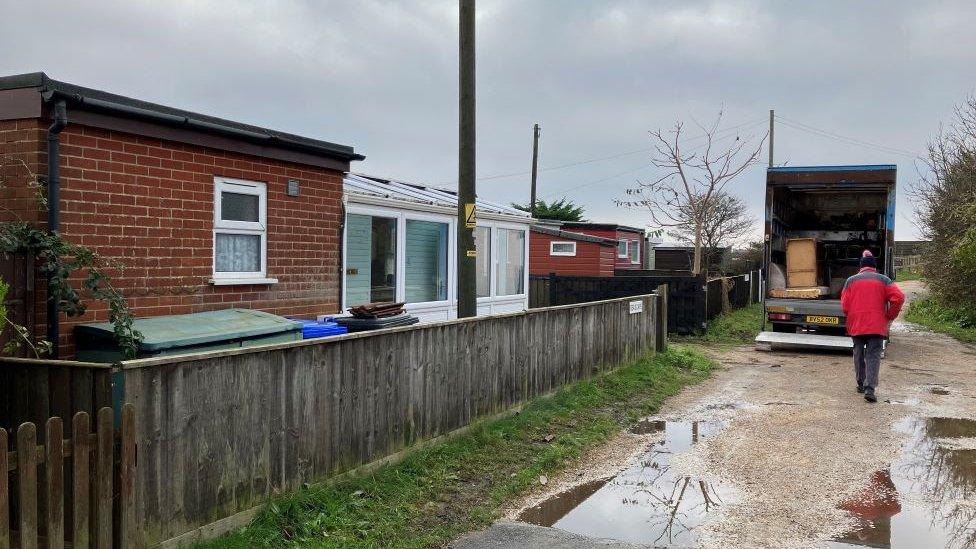 Moving vans have arrived to move the last of the family's belongings out before the demolition