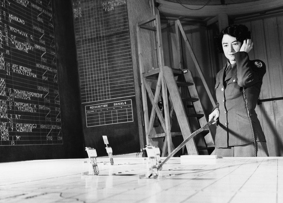 Corporal Geraldine Hill of the Women's Army Corps, receives reports on aircraft positions in the plotting room of the 3rd Bomb Division at Elveden Hall, Suffolk