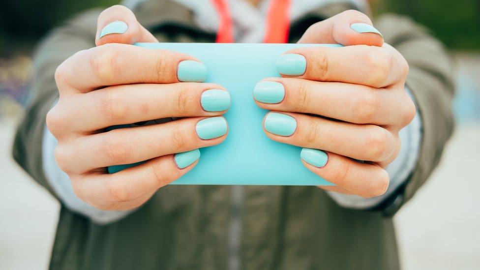 Woman holding out mobile phone