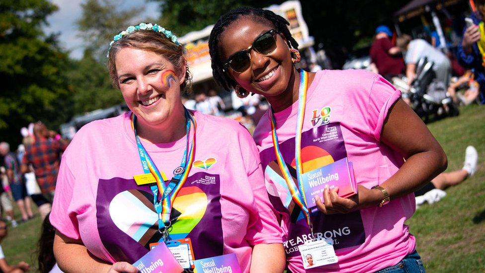 Two people smiling in the sunshine at a previous Pride in Surrey