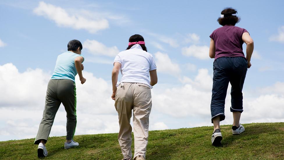 Three women walking uphill