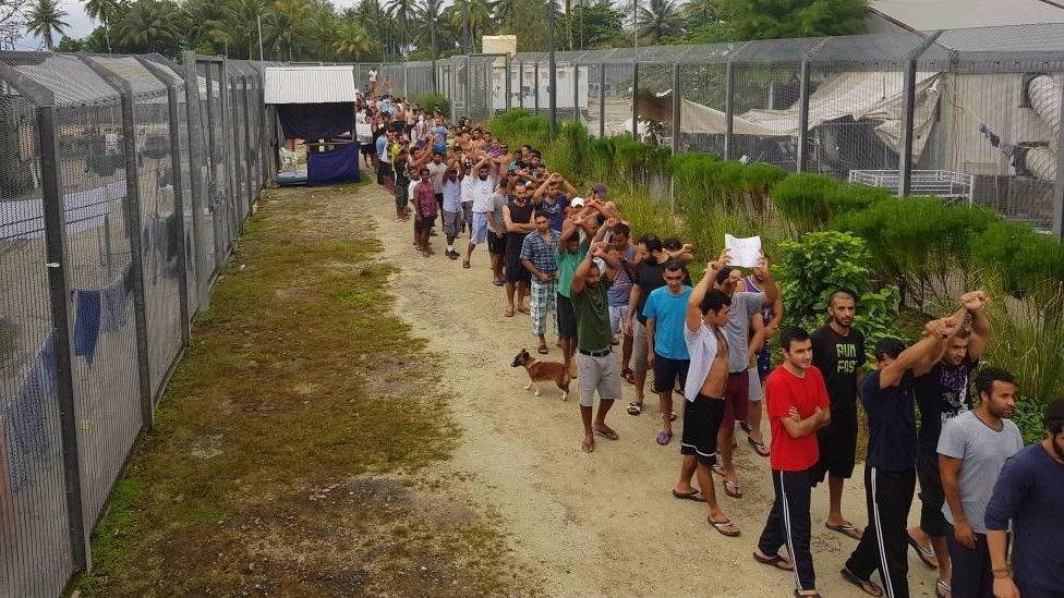 Refugees march across the camp in Manus