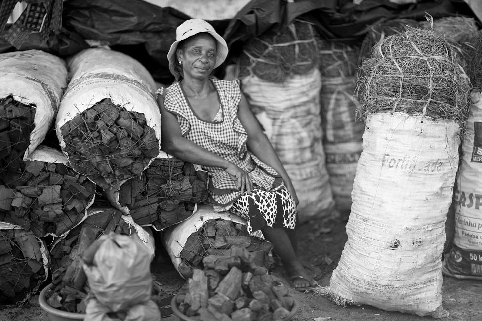 Dina Macanje next to bags of charcoal