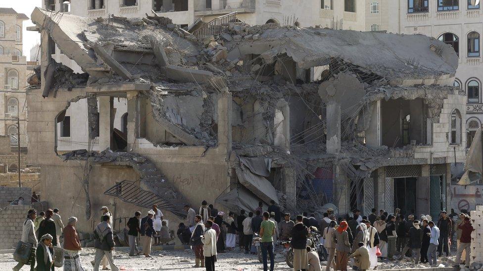 People gather outside the house of court judge Yahya Rubaid after a Saudi-led air strike destroyed it, killing him, his wife and five other family members, in Yemen's capital Sanaa