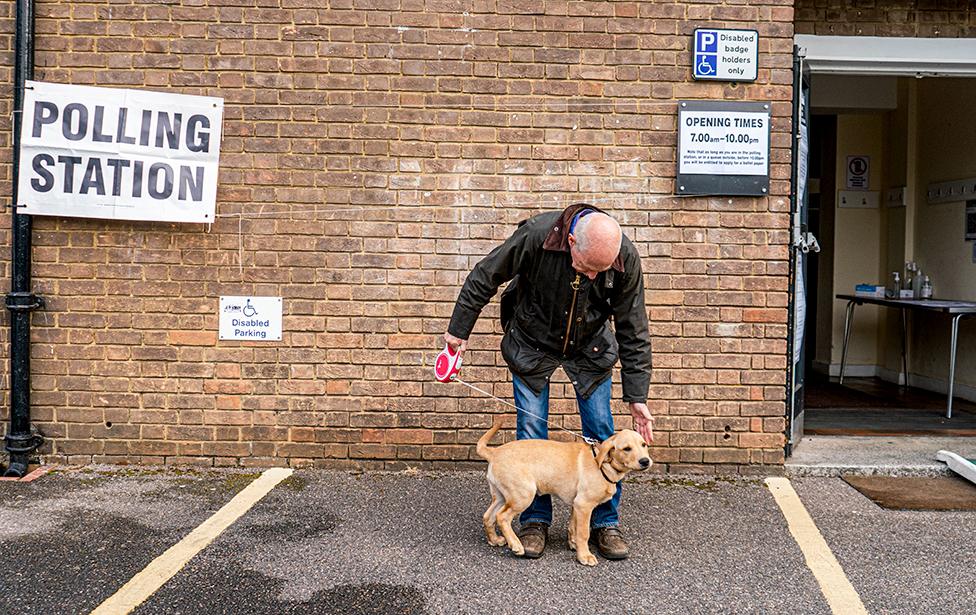 A dog and its owner outside an election polling station in Wimbledon, London