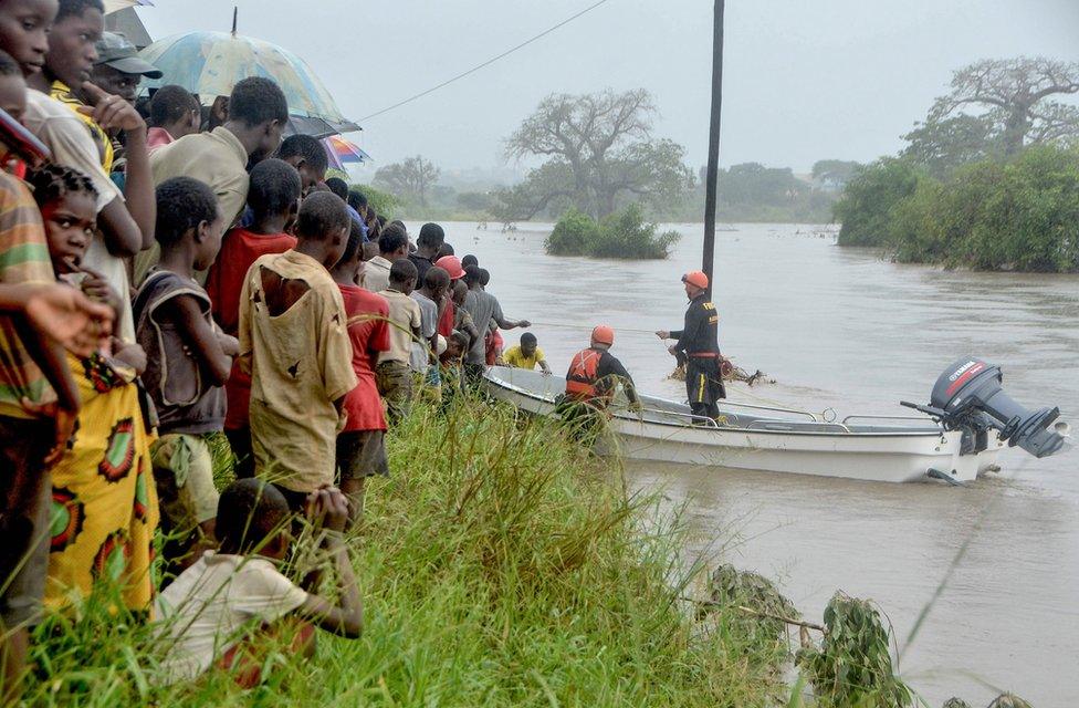 Residents observe a Brazilian firefighter team at work in Mazive, southern Mozambique