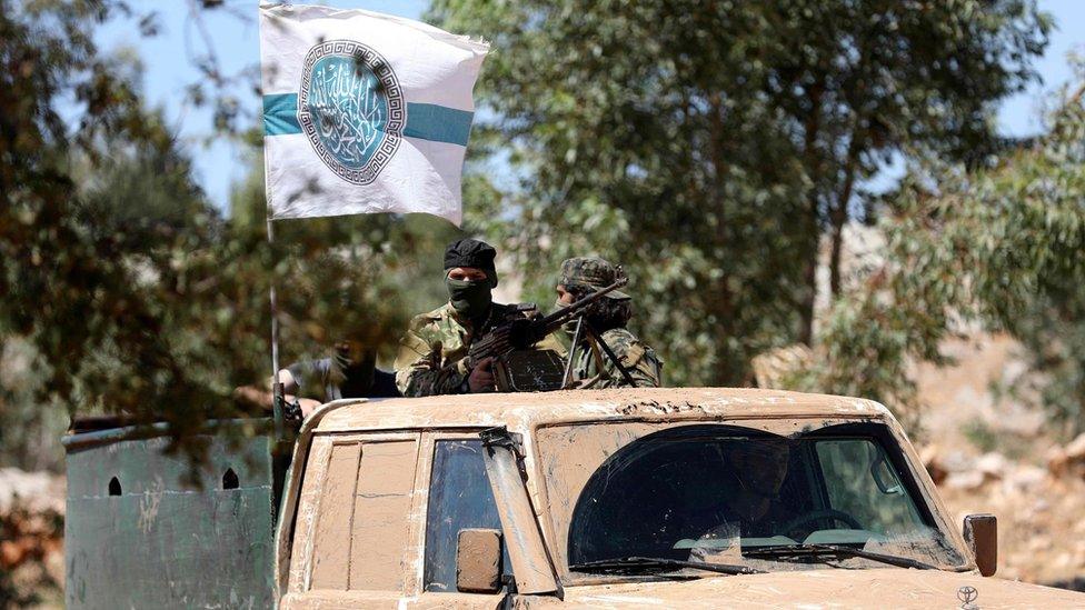 Members of jihadist alliance Hayat Tahrir al-Sham ride vehicle after training graduation ceremony in Idlib (14 August 2018)