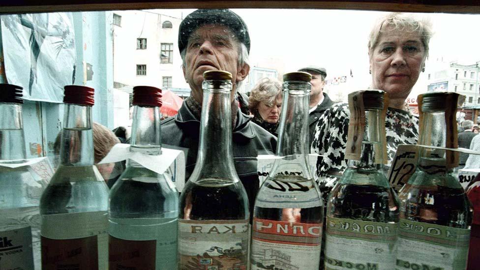 People browse for vodka in a street kiosk in Moscow, 1997