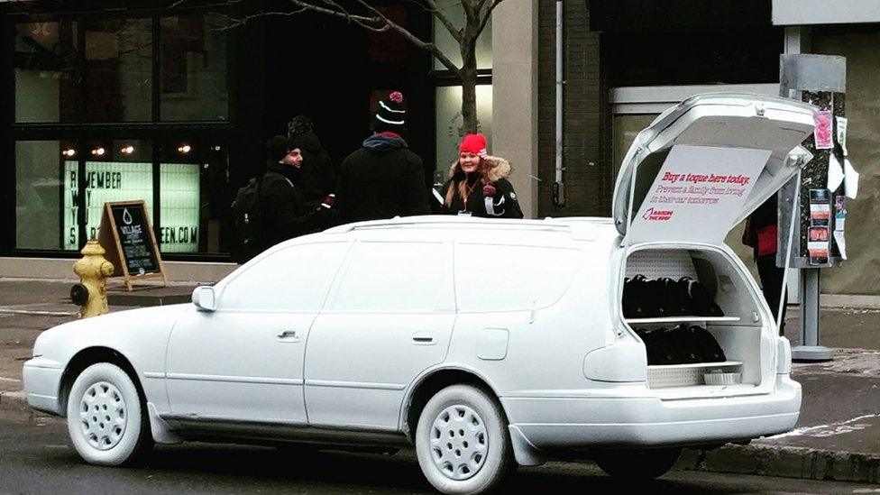 A car painted white with the pop-up shop in its boot