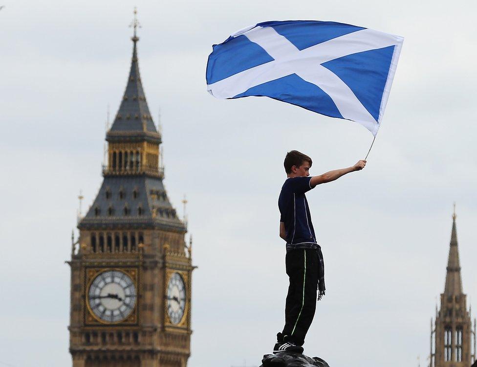 A boy waves a flag as Scotland fans gather in Trafalgar Square ahead of their friendly match against England tonight on August 14, 2013 in London,