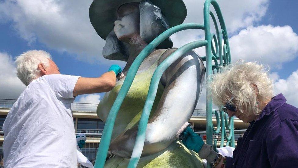 Residents scrubbing the paint off the sculpture