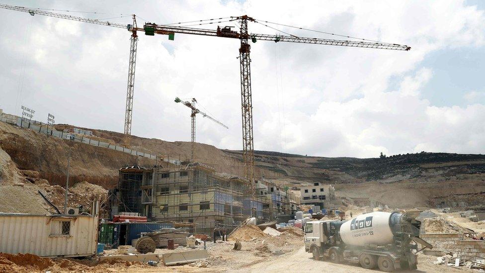 Photo taken on 14 April 2016 shows workers at a construction site in the Jewish settlement of Givat Zeev in the occupied West Bank