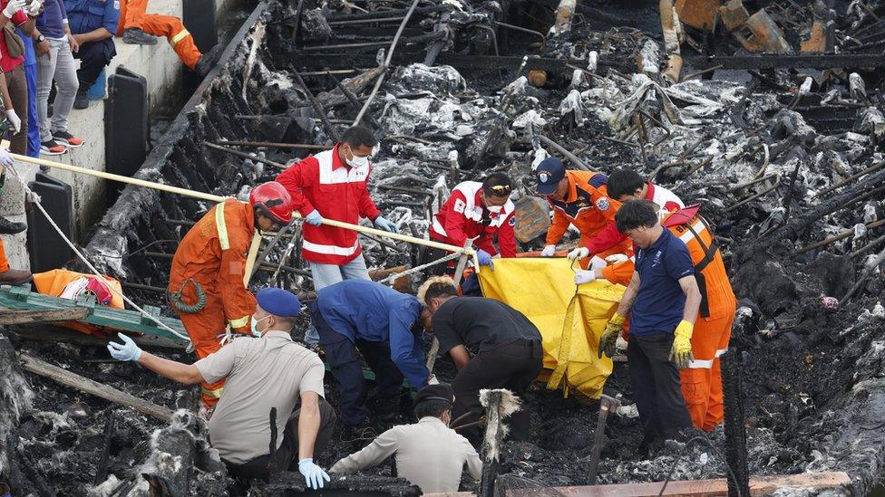 Workers remove bodies of those who died from the ferry on 1 January 2017