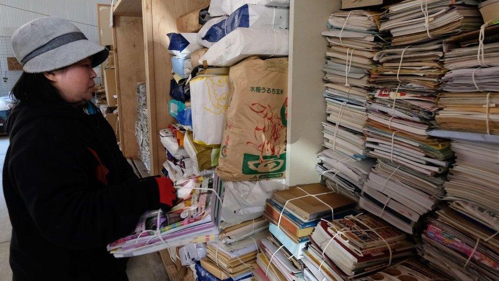 A worker sorts newspapers and magazines for recycling in the "eco-town" of Kamikatsu