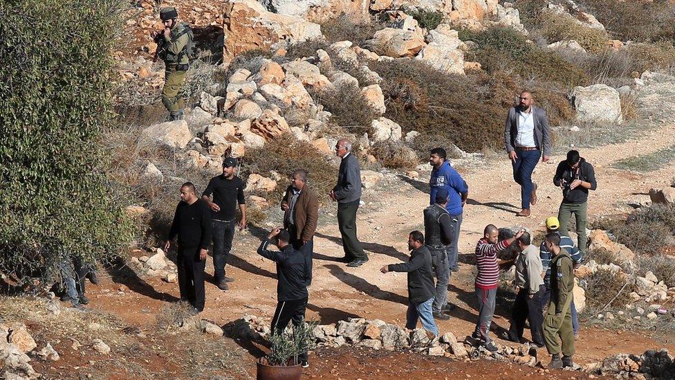 Palestinian men argue with Israeli soldiers after an incident near the West Bank village of Qusra (30 November 2017)