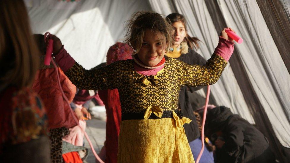 A girl skipping in a refugee camp in Iraq