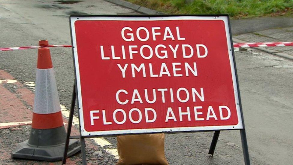 A sign reads 'caution flood ahead'