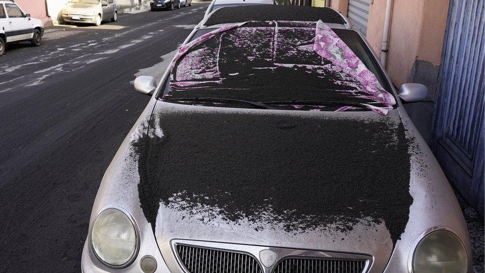 A car is covered in volcanic ashes from Mount Etna in Santa Venerina, Italy, 28 February 2021