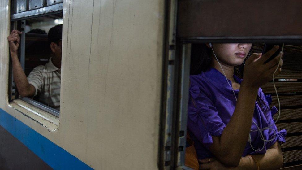 Woman listens to headphones on the train.