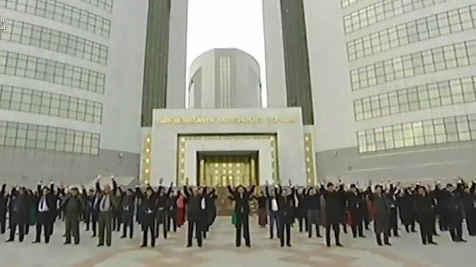 Still from state TV of Turkmen exercising outside their offices