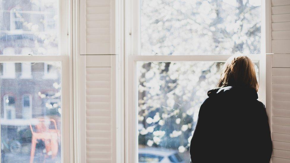 Young person looking out of window