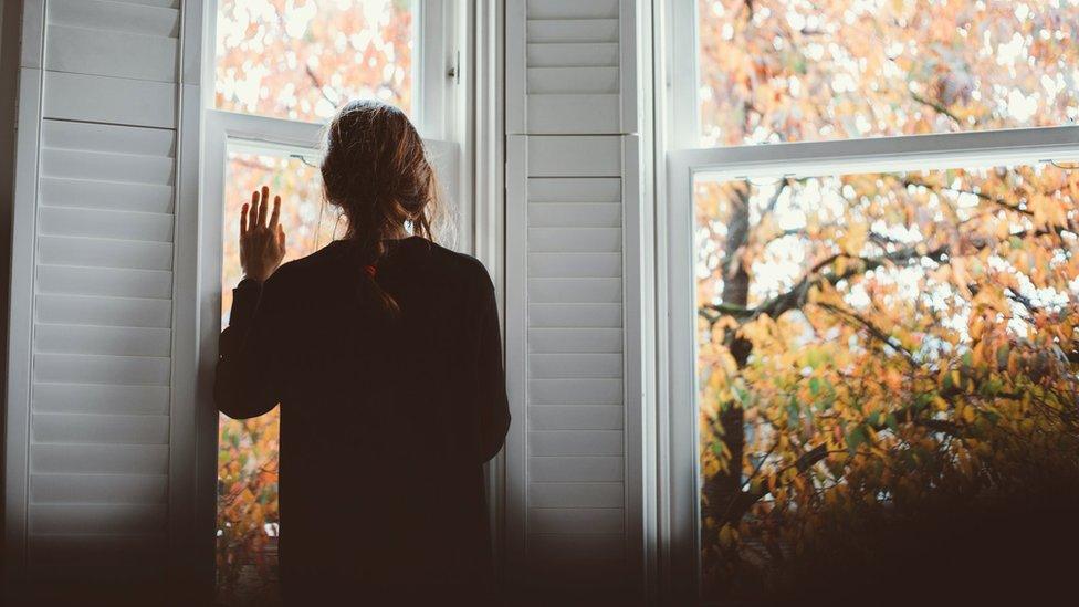 picture of lady looking out of a window