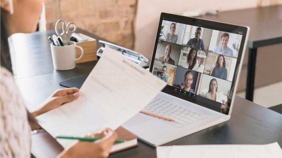 A woman attending a Zoom video conferencing meeting