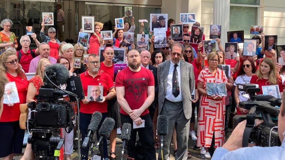 Group of people holding photos of loved ones