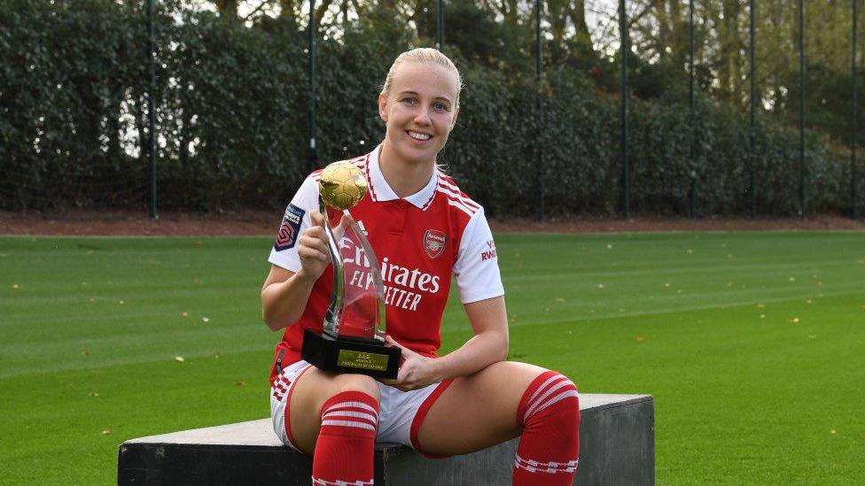 Beth Mead holding a trophy.