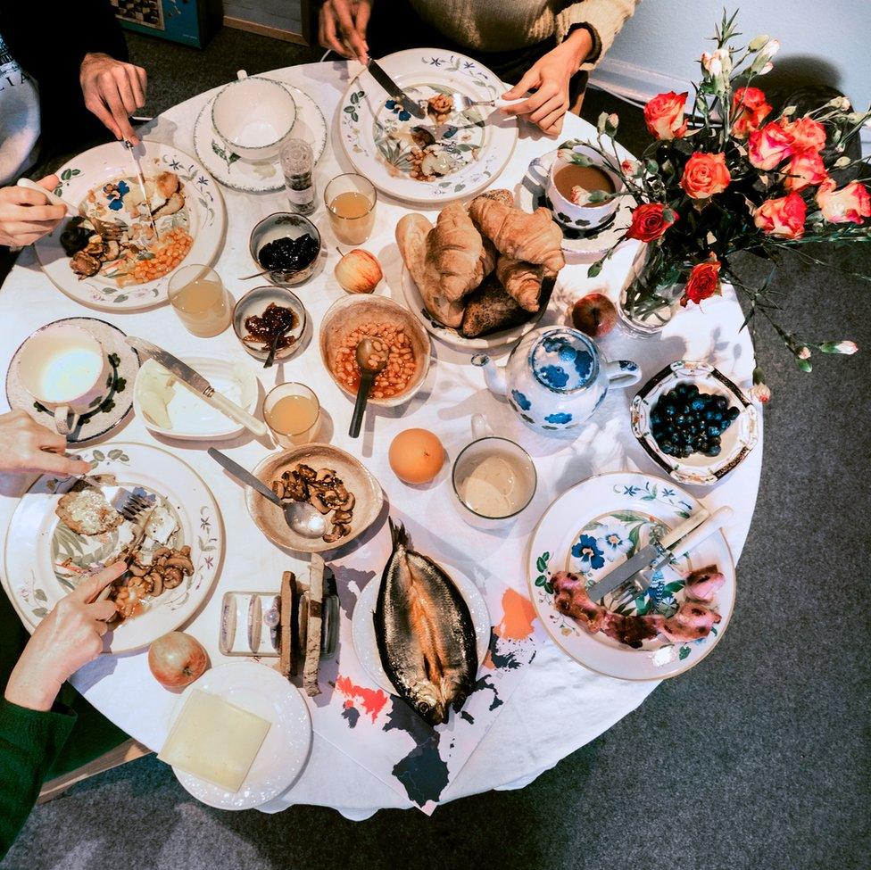 An image of a spread of breakfast food with people eating