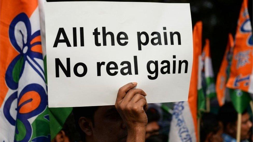 An Indian supporter of the Chief Minister of the state of West Bengal and leader of the opposition Trinamul Congress (TMC) party Mamata Banerjee holds a placard as she delivers a speech during a protest against demonetisation in New Delhi on November 23, 201