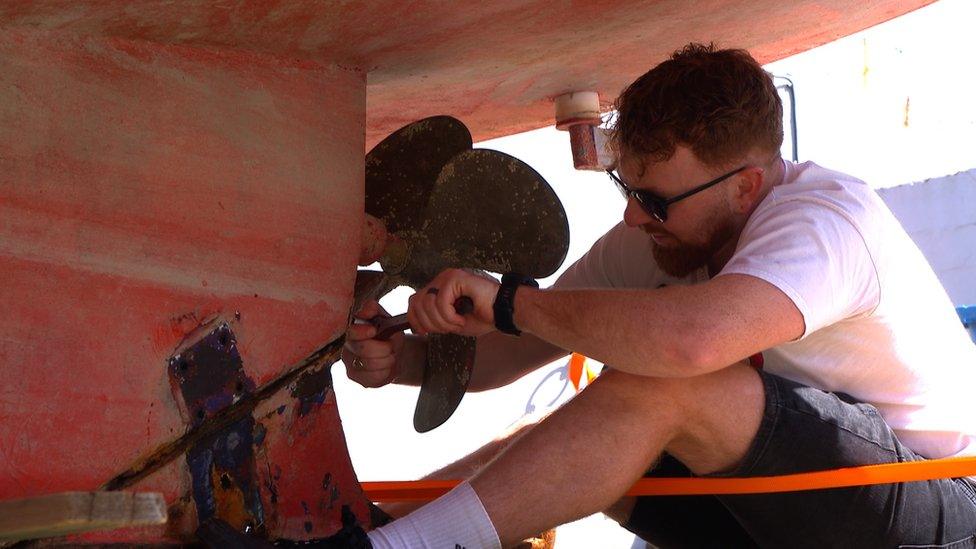 Connor Carré fixes a boat