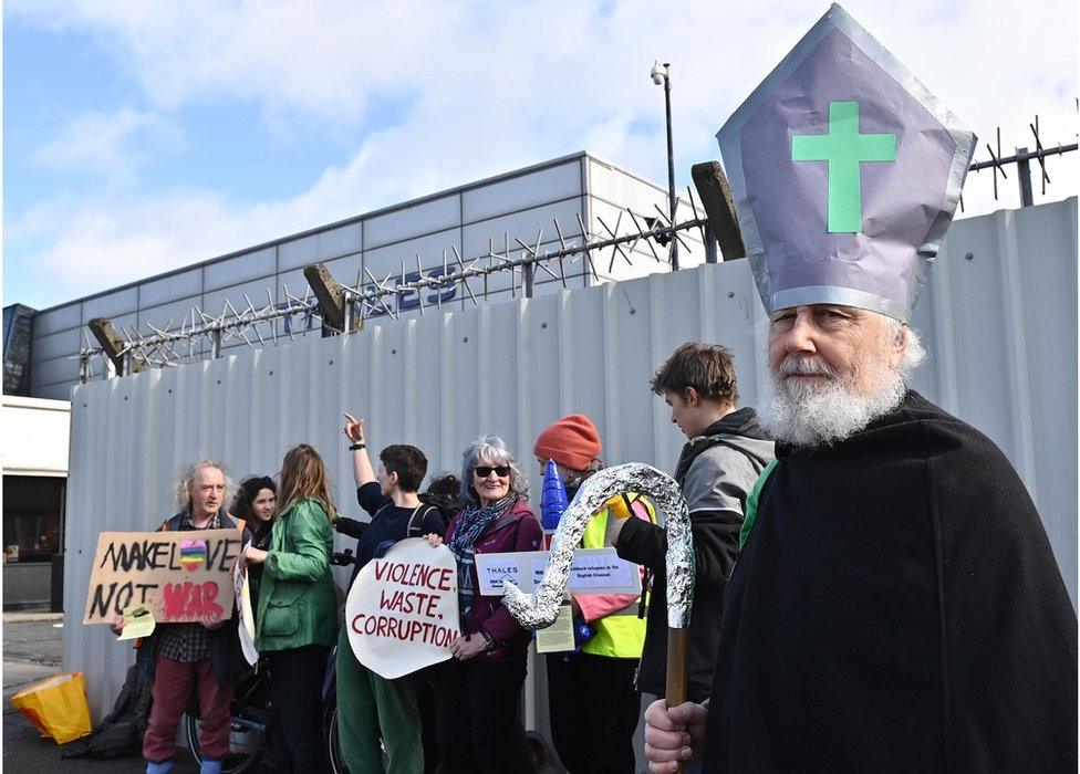 A protestor dressed as St Patrick outside the Thales plant near Belfast