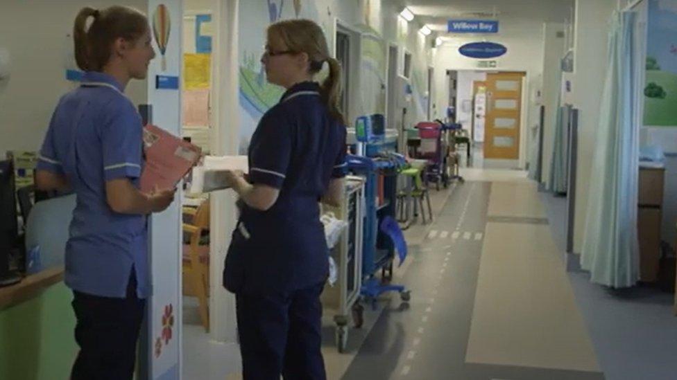 Hospital ward with two nurses in the foreground