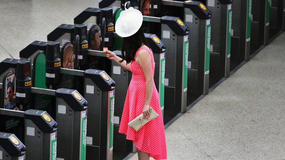 A woman enters a ticket gate for a train to Ascot at Waterloo Station in London, Britain June 22, 20