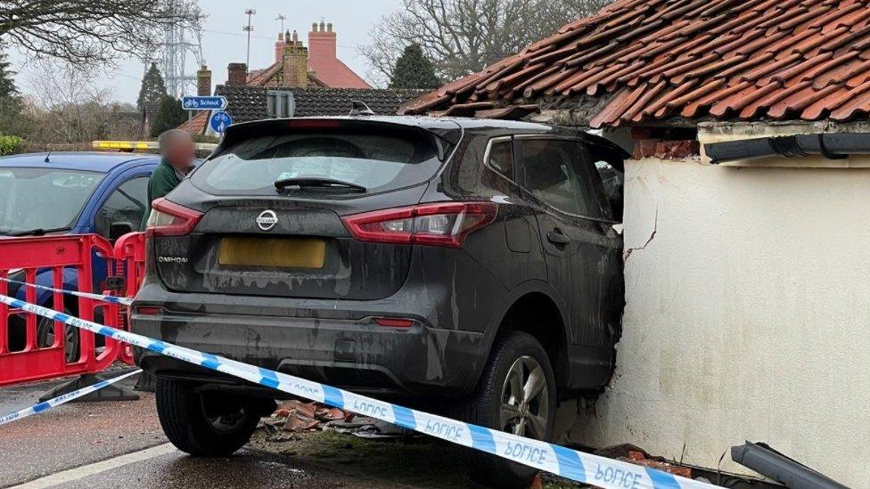 Car in the side of a pub